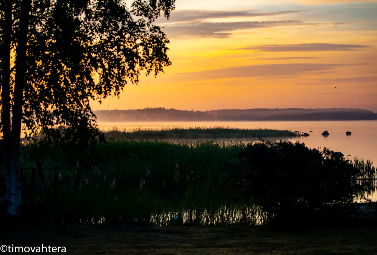 Finnish landscape in summer, suntirse and morning fog over the sea.